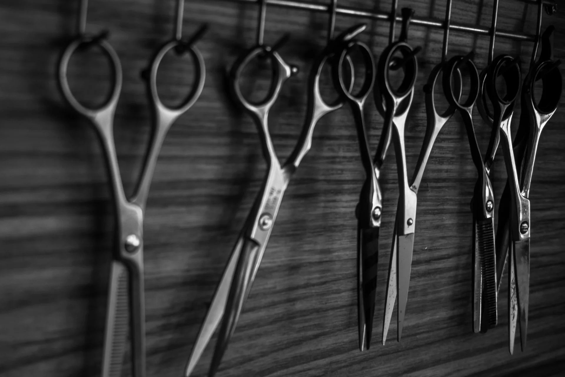 Scissors hanging on the wall getting ready to be sharpened.